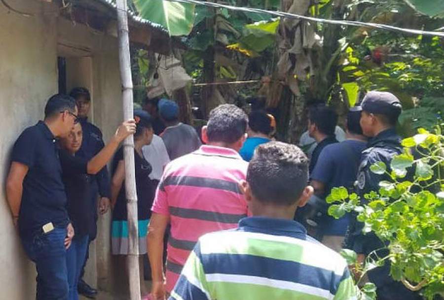 Crowd gathers beside a Choluteca home with lush greenery as investigators and locals discuss a shocking case involving Óscar Efraín Blanco.