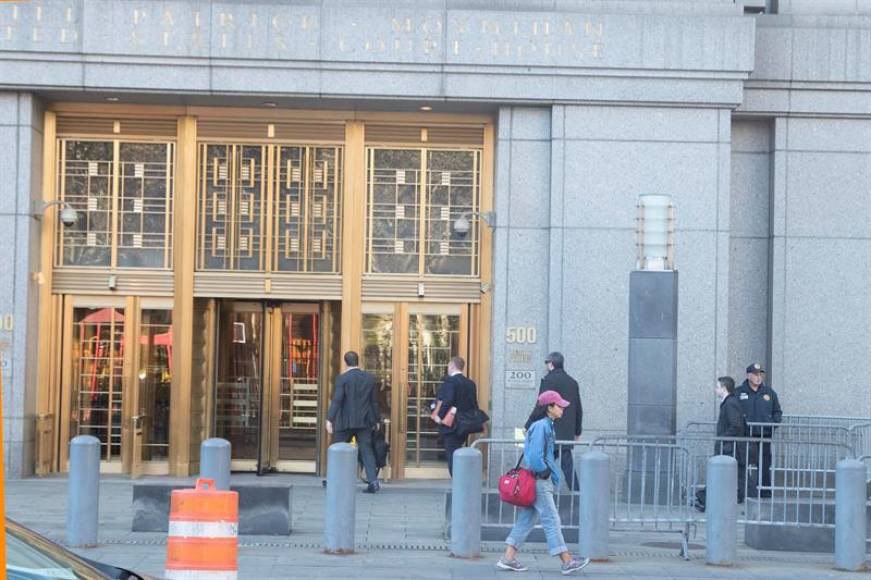 Tony Hernández courthouse scene with golden-glass doors at a New York building, people walking in and security barriers outside, reflecting a high-profile legal appearance.