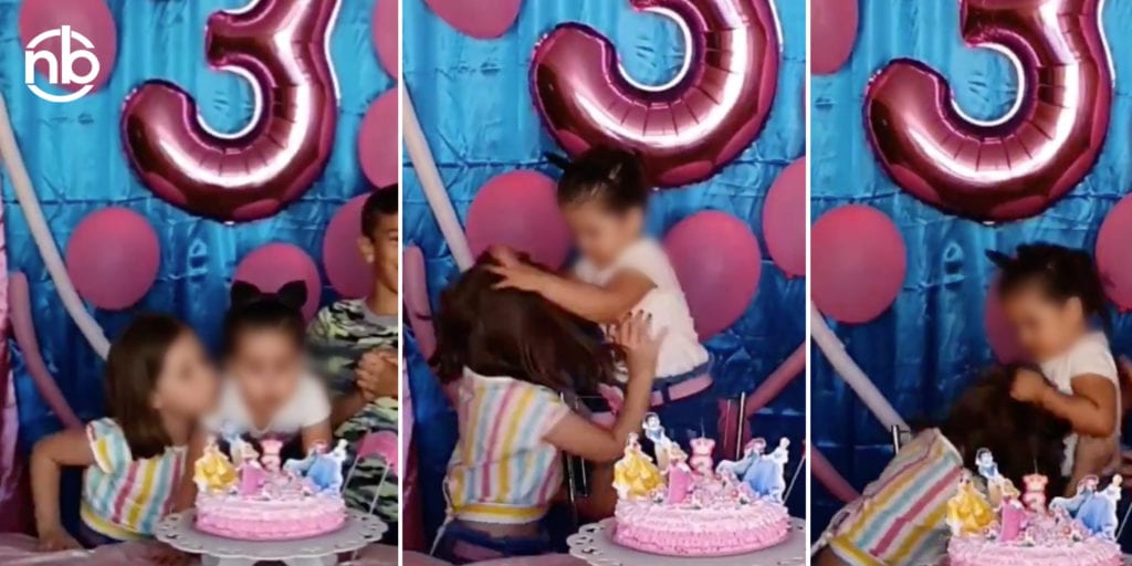 Dos hermanitas peleando por apagar una vela.