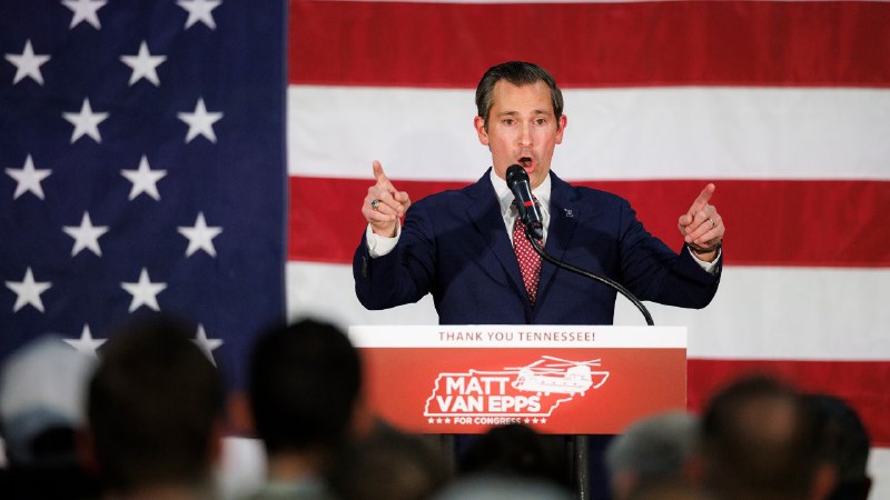 Matt Van Epps, con traje azul y banderas de EE. UU., habla ante un micrófono durante la elección especial en Tennessee 2025.