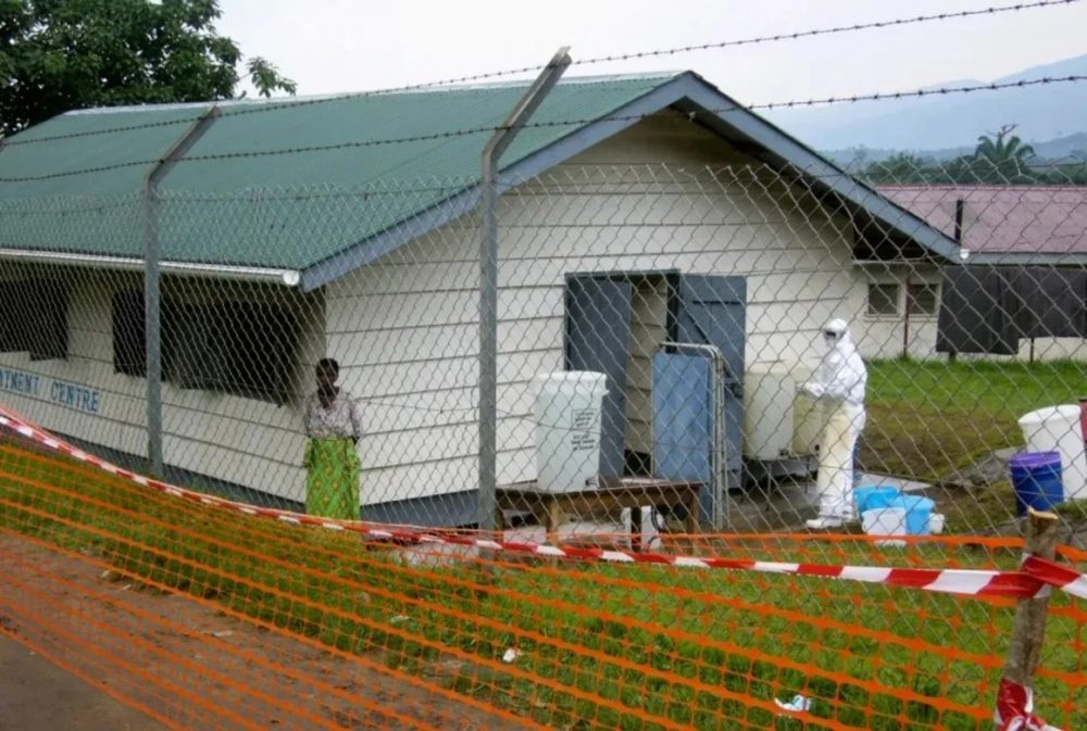 Valla metálica y contención sanitaria con personal de protección en un campamento por el nuevo brote de Ébola durante la epidemia, en alerta mundial.